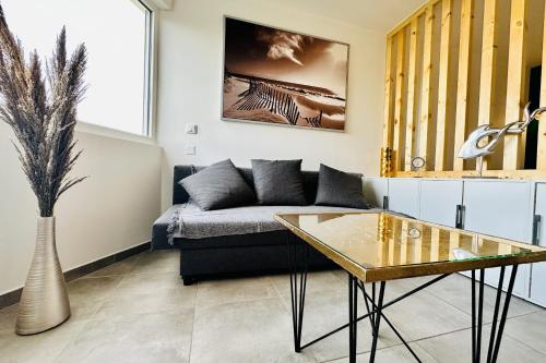 un salon avec un canapé et une table dans l'établissement L'Emeraude au soleil Studio avec coin nuit dans résidence sur la plage, au Grau-du-Roi