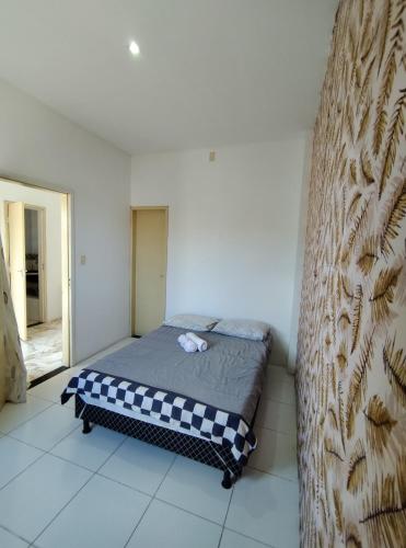 um quarto com uma cama com um cobertor xadrez em Apto 2/4 completo em Serrinha