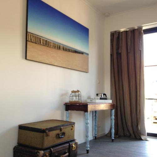 a room with a desk and a table with luggage at De Weegbrug in IJzendijke