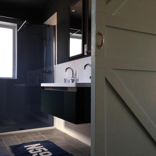 a bathroom with a sink and a mirror at De Weegbrug in IJzendijke