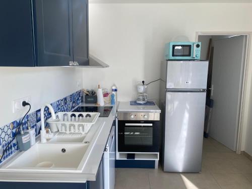 eine kleine Küche mit Kühlschrank und Spüle in der Unterkunft Entre terre et mer in Écault