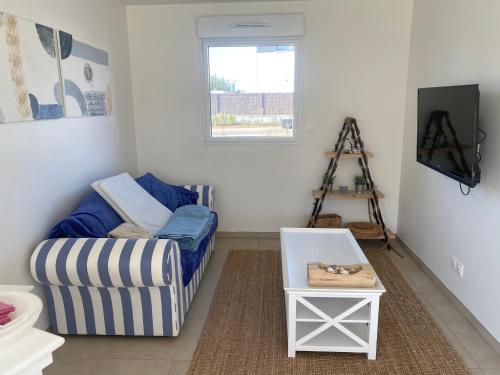 un salon avec un canapé et une télévision dans l'établissement Entre terre et mer, à Écault