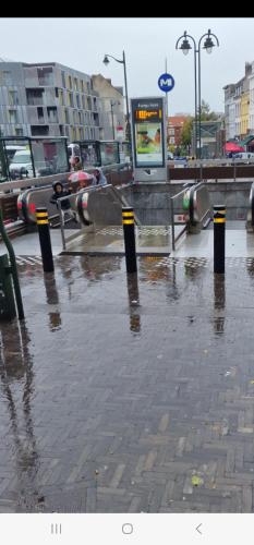 a flooded street with black and yellow poles in a city at Chambre chez Anita in Brussels