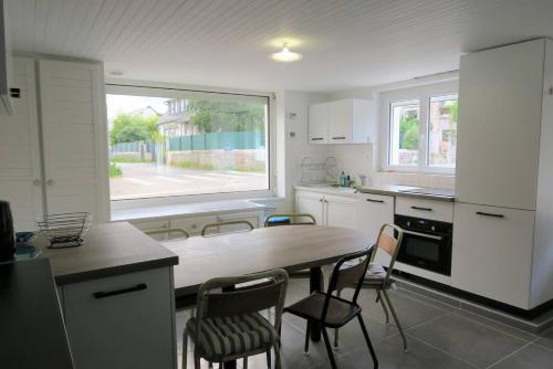 une cuisine avec une table et des chaises et une fenêtre dans l'établissement Maison 5 pers à 640m de la plage de Trestraou à PERROS-GUIREC - Réf 909, à Perros-Guirec