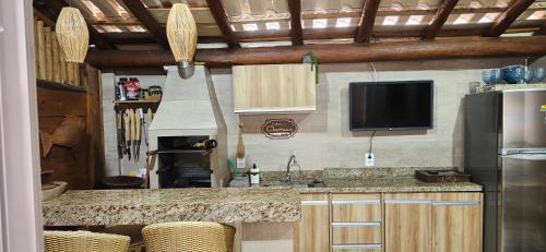 eine Küche mit einer Theke und einen TV in einem Zimmer in der Unterkunft Village Itacimirim Summer Houses in Itacimirim