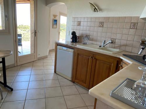 une cuisine avec un évier et un lave-vaisselle dans l'établissement Appartement vue mer en Résidence avec piscine, à Porto-Vecchio