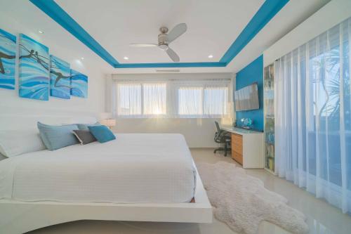 una camera da letto con un letto bianco e soffitti blu di Luxury 4 Bedroom Penthouse with Private Jacuzzi steps from hotel zone a Cancún