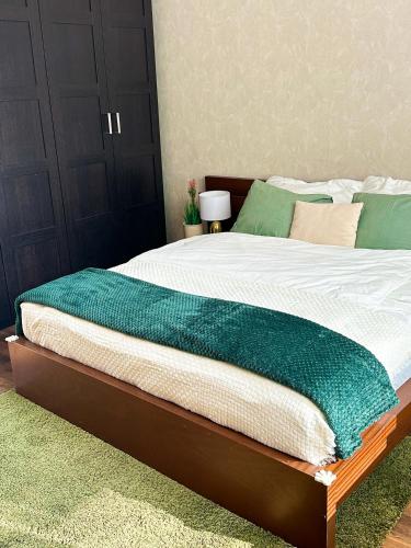 een groot bed met een groene deken erop bij Spacious city centre apartment in Bratislava