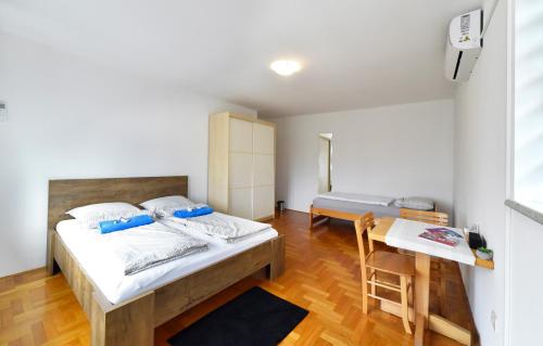 a bedroom with a bed and a table with a chair at GreenHouse in Zagreb
