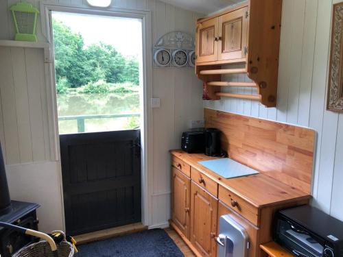 a kitchen with a wooden counter and a window at Snug & Secluded Lakeside Shepherds Hut 'Carp' in Uckfield