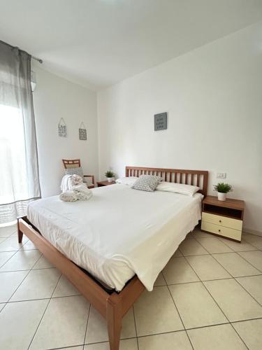 a bedroom with a large bed with white sheets at San Martino-Flexrent Immobiliare Abissinia in Riccione