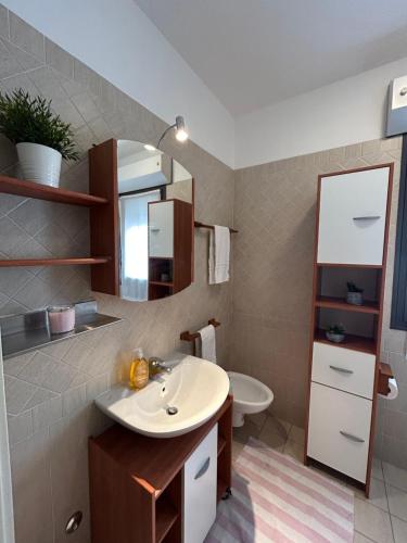 a bathroom with a sink and a toilet at San Martino-Flexrent Immobiliare Abissinia in Riccione
