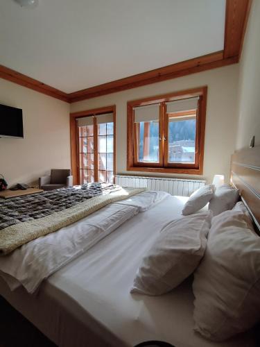 a large white bed in a room with windows at Apartment 216 NiM unutar kompleksa Aparthotel Vučko in Jahorina