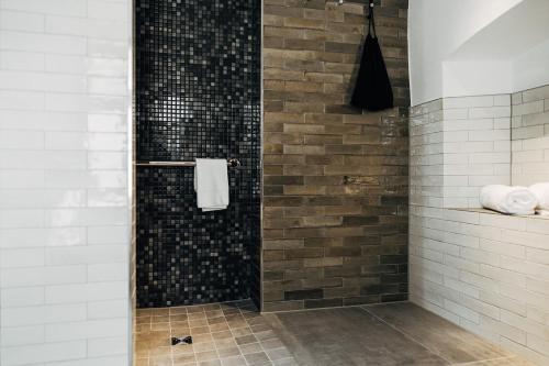 a bathroom with a shower with black and white tiles at Bootshaus Amberg in Amberg