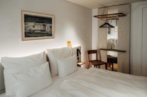 a bedroom with a white bed with white pillows at Bootshaus Amberg in Amberg