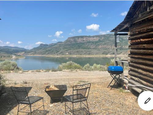 un grupo de sillas y una parrilla junto a un lago en Sapinero Village Campground on Blue Mesa, en Gunnison