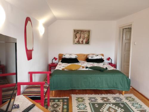 1 dormitorio con 1 cama con manta verde en Cabana La Plai Est - idyllic natural setting, en Vatra Dornei