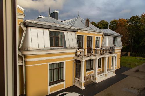 ein gelbes und weißes Haus mit einem Balkon in der Unterkunft Kaunas Embassy Apartments in Kaunas