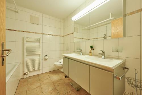 uma casa de banho com 2 lavatórios e um WC em Apartment Silberhorn, outstanding view, spacious, family friendly em Lauterbrunnen