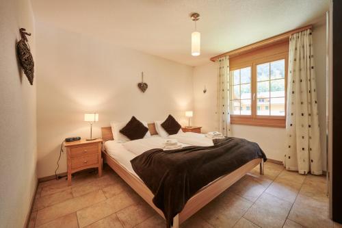 um quarto com uma cama grande e uma janela em Apartment Silberhorn, outstanding view, spacious, family friendly em Lauterbrunnen