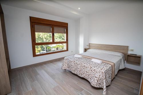 1 dormitorio con cama y ventana en Apartamentos 7 puentes sierra Cazorla, en Burunchel