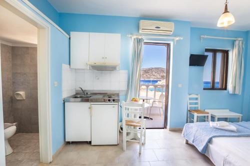 a kitchen with blue walls and a bathroom with a bed at P i g a d i a B a y in Karpathos Town