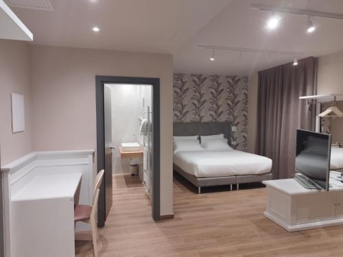 a bedroom with a bed and a desk and a mirror at Campiglione Hotel in Bastia Umbra