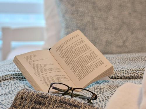 a book and a pair of glasses sitting on a couch at Roman Apartman in Sremska Mitrovica