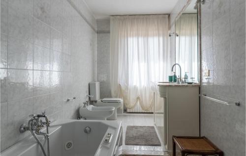 Baño blanco con bañera y lavamanos en Villa Del Mandarino, en Capannori