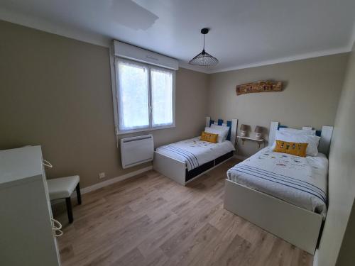 une petite chambre avec deux lits et une fenêtre dans l'établissement Maison de vacances Ty Hortensia, à Ploumoguer