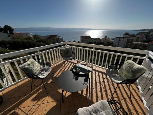 balcone con sedie, tavolo e vista sull'oceano di Kavajin Rooms a Duće