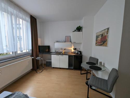 ein Wohnzimmer mit einem Tisch und einer Küche in der Unterkunft Pension am Park in Pforzheim