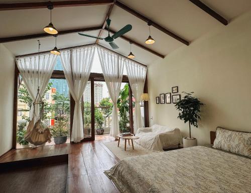 a bedroom with a bed and a large window at Forest Tag - 6/8 Ha Noi in Hue