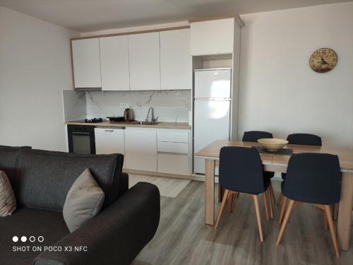 a living room with a table and a kitchen at Apartment Prizren New and Modern in Prizren