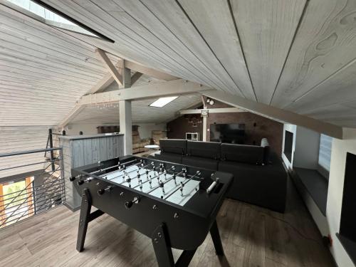 a ping pong table in the middle of a room at Duplex avec poêle à granulés et garage à motos in Montaigut-le-Blanc