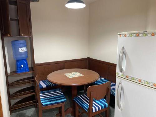 a small kitchen with a table and a refrigerator at Excelente ubicación Cochabamba in Cochabamba