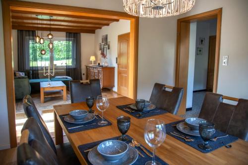 a dining room with a wooden table with wine glasses at Casa Oos in Rockeskyll