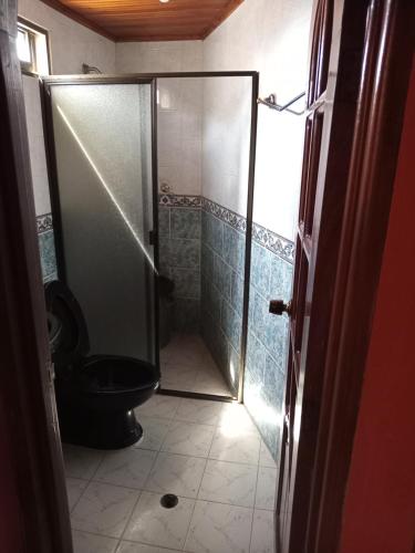 a bathroom with a shower and a black toilet at Comoda habitacion in Valledupar