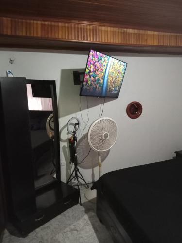 a room with a fan and a picture on the wall at Comoda habitacion in Valledupar