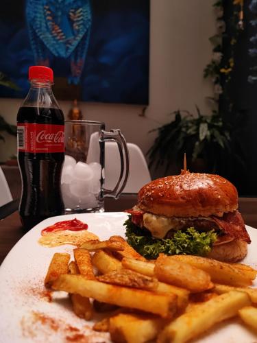 Un sándwich y papas fritas en un plato con coca. en Vymar and Loto Azul, en Pasto