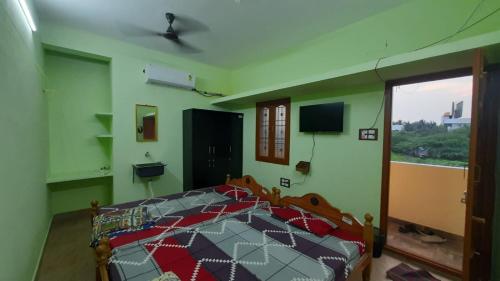 a bedroom with a bed in a room with a window at Vikistays in Chennai