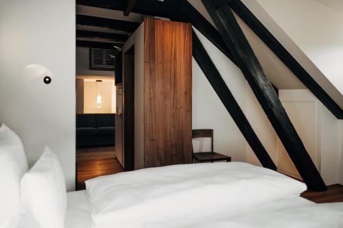 a bedroom with a white bed and a wooden door at Bootshaus Amberg in Amberg