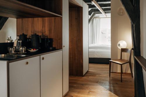 a kitchen with white cabinets and a room with a bed at Bootshaus Amberg in Amberg