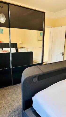 - une chambre avec un lit et un grand miroir dans l'établissement Hestia Travel Slough, à Slough