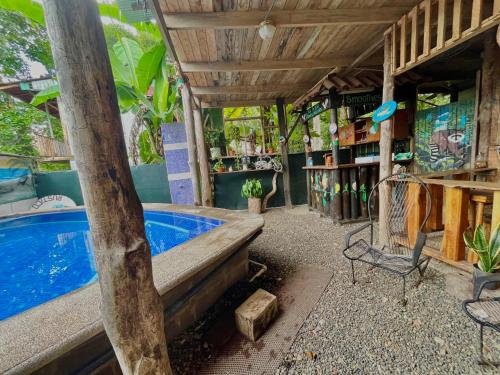 a patio with a pool and a table and a chair at Hostel Rústico MarAbi in Tarcoles