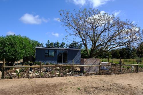 a tiny house in a field with a fence at Blue Sky Retreat in Vredenburg