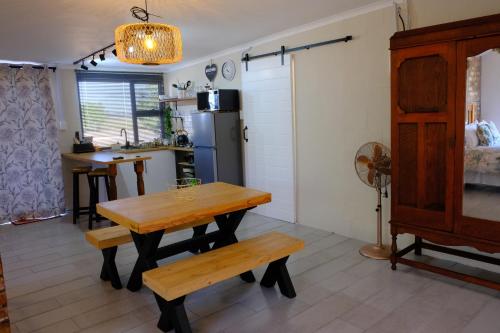 a kitchen with a table and benches in a room at Blue Sky Retreat in Vredenburg