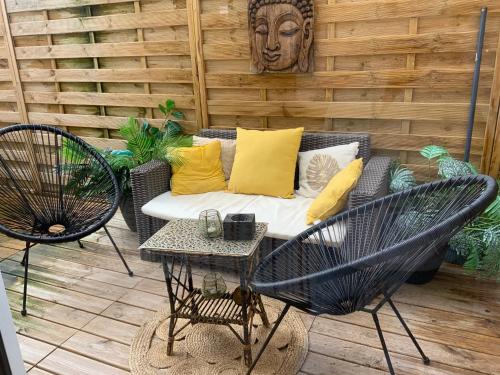 a patio with a couch and two chairs and a table at Family lodg in Calais