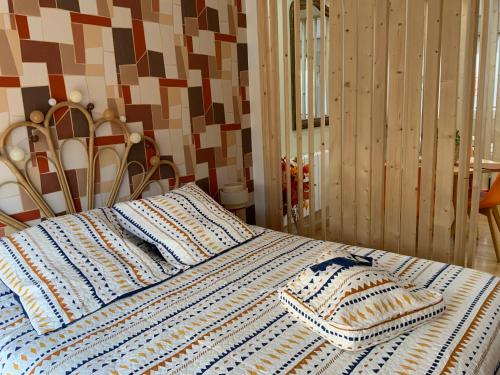 a bed with a blue and white blanket on it at Family lodg in Calais