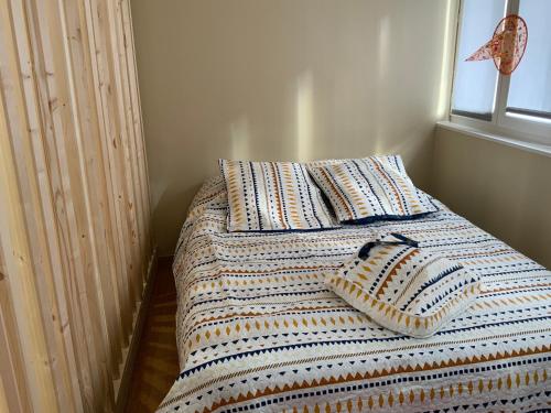 a bed with two pillows on it in a bedroom at Family lodg in Calais